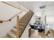 Bright foyer featuring wood floors, staircase with black metal railings, and open living area at 3363 W 32Nd Ave, Denver, CO 80211
