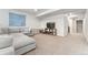 Finished basement with a plush gray sectional sofa, wall decor, and a view into another finished section at 7137 S Vandriver Way, Aurora, CO 80016