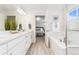 Bright bathroom featuring dual sinks, a soaking tub, and an adjacent bedroom at 7137 S Vandriver Way, Aurora, CO 80016