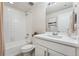 Clean bathroom featuring a tiled shower-tub, toilet, vanity, and white cabinets at 7137 S Vandriver Way, Aurora, CO 80016