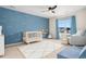 Bedroom with blue walls, wave decorations, a crib, and a comfortable chair at 7137 S Vandriver Way, Aurora, CO 80016