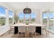 Bright dining room with large windows and modern light fixture illuminating a stylish table at 7137 S Vandriver Way, Aurora, CO 80016