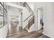 Open-concept foyer features sleek hardwood floors, a modern staircase with black metal railings, and abundant natural light at 7137 S Vandriver Way, Aurora, CO 80016