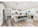 Open concept kitchen with island, breakfast bar, modern lighting, stainless appliances, and view to dining and outdoor spaces at 7137 S Vandriver Way, Aurora, CO 80016