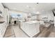 Open-concept kitchen featuring a large island with bar seating, modern appliances, and seamless flow to the living areas at 7137 S Vandriver Way, Aurora, CO 80016
