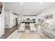 Open floor plan showcases a modern kitchen with sleek white cabinets and an inviting seating area, perfect for entertaining at 7137 S Vandriver Way, Aurora, CO 80016