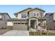 Two-story house with gray siding, stone accents, and a two-car garage at 4823 Astor Pl, Brighton, CO 80601