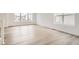 Living room with large windows and light wood-look floors at 4823 Astor Pl, Brighton, CO 80601