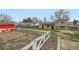 Large backyard featuring white fencing, a colorful shed, and potential gardening beds at 11121 W 107Th Pl, Westminster, CO 80021