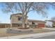 Charming home exterior with mature shade tree, brick accents, and an attached garage at 11121 W 107Th Pl, Westminster, CO 80021