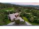 Aerial view of large home, driveway, and manicured grounds bordered by green trees at 786 International Isle Dr, Castle Rock, CO 80108
