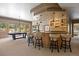 Entertainer's basement bar with seating, elegant counter and cabinets, and a pool table in the background at 786 International Isle Dr, Castle Rock, CO 80108