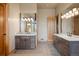 Bathroom with double vanities, stone countertops, and hardwood cabinets at 786 International Isle Dr, Castle Rock, CO 80108