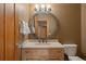 Charming bathroom featuring a light wood vanity, round mirror, toilet, and soft neutral tones at 786 International Isle Dr, Castle Rock, CO 80108