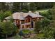 Expansive stone house featuring large windows and outdoor seating, nestled among lush trees at 786 International Isle Dr, Castle Rock, CO 80108
