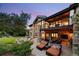 Backyard with patio seating on a stone home exterior with views, balconies, and an outdoor fireplace at 786 International Isle Dr, Castle Rock, CO 80108