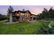 Stone home exterior with green lawn, patios, and balconies, framed by mature trees at 786 International Isle Dr, Castle Rock, CO 80108