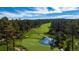 Aerial view of a pristine golf course with a winding stream, a tranquil pond, and lush green fairways at 786 International Isle Dr, Castle Rock, CO 80108