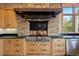 Close up of the kitchen range, stone backsplash, stainless steel appliances, and hardwood cabinets at 786 International Isle Dr, Castle Rock, CO 80108