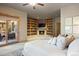 Inviting main bedroom with built-in shelving, fireplace, sliding glass doors to the patio, and plush bedding at 786 International Isle Dr, Castle Rock, CO 80108