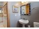 Stylish powder room with gray walls, framed mirror, pedestal sink, and decorative artwork at 786 International Isle Dr, Castle Rock, CO 80108
