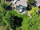 Aerial view showcasing a well-maintained backyard, deck, mature trees, and lush greenery at 8296 S Reed St, Littleton, CO 80128