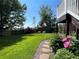 Inviting backyard featuring a stone path, beautiful flowerbeds, and a lush green lawn at 8296 S Reed St, Littleton, CO 80128