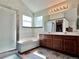 Well-lit bathroom with a walk-in shower, a soaking tub, double sinks, and ample vanity space at 8296 S Reed St, Littleton, CO 80128