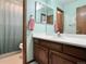 Bathroom featuring wood vanity, a white countertop, a sink, and a mirror with an open view of the toilet at 8296 S Reed St, Littleton, CO 80128
