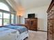 Bedroom featuring natural light from an arched window, complemented by a wooden dresser and a cozy bed at 8296 S Reed St, Littleton, CO 80128