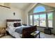 Bedroom with a big picture window, white ceiling, natural light, and a well-made sleigh bed at 8296 S Reed St, Littleton, CO 80128