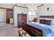 A sun-lit bedroom with a sleigh bed, stylish dresser, and bathroom with a soaking tub at 8296 S Reed St, Littleton, CO 80128