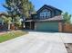 Charming two-story home featuring a green facade, brick accents, and a spacious driveway at 8296 S Reed St, Littleton, CO 80128
