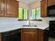 Corner view of the kitchen highlighting the black appliances, wood cabinets, and the stainless sink at 8296 S Reed St, Littleton, CO 80128