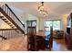Inviting dining room with a staircase, light hardwood floors, and view into the adjacent living room at 8296 S Reed St, Littleton, CO 80128