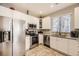 Modern kitchen with stainless steel appliances, white cabinets, and ample counter space at 4396 S Quail Way, Littleton, CO 80127