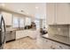 Bright kitchen featuring white cabinets, stainless steel appliances, and tile flooring at 4396 S Quail Way, Littleton, CO 80127