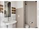 Modern bathroom featuring a pedestal sink, decorative mirror, and a walk-in shower at 6072 Chester St, Denver, CO 80238