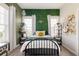 Charming bedroom featuring an accent wall, decorative shelves, and plenty of natural light at 6072 Chester St, Denver, CO 80238