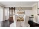 Elegant dining room featuring a rustic wood table, barn door, and stylish chandelier at 6072 Chester St, Denver, CO 80238