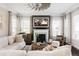 Bright living room with fireplace, ceiling fan, neutral color palette, and large windows at 6072 Chester St, Denver, CO 80238