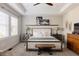 Serene main bedroom featuring a tray ceiling, bench, and bedside tables for a calming retreat at 6072 Chester St, Denver, CO 80238