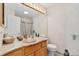 Bathroom with wood cabinets, granite countertop, and large mirror at 3337 W 113Th Ave, Westminster, CO 80031