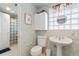 Cozy bathroom with glass block accents, pedestal sink, and updated fixtures at 3337 W 113Th Ave, Westminster, CO 80031