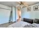 Bedroom showcasing a ceiling fan, mounted clothing rack, and a view into the hallway and stairs at 8483 Sandreed Cir, Parker, CO 80134