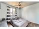 Bedroom with a window dressed with black and white curtains, wood floors, and a ceiling fan at 8483 Sandreed Cir, Parker, CO 80134