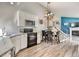 Kitchen with gray walls, stainless steel appliances, a dining table, and a staircase leading to the second level at 8483 Sandreed Cir, Parker, CO 80134