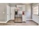 Stainless steel refrigerator surrounded by white cabinets and gray walls next to an entrance door to the exterior at 8483 Sandreed Cir, Parker, CO 80134