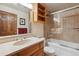 Bathroom featuring a combination bathtub and shower, neutral tile, and a wood vanity at 7312 S Moore Ct, Littleton, CO 80127