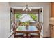 Cozy dining area with a large window, wooden table, and stylish chandelier at 7312 S Moore Ct, Littleton, CO 80127